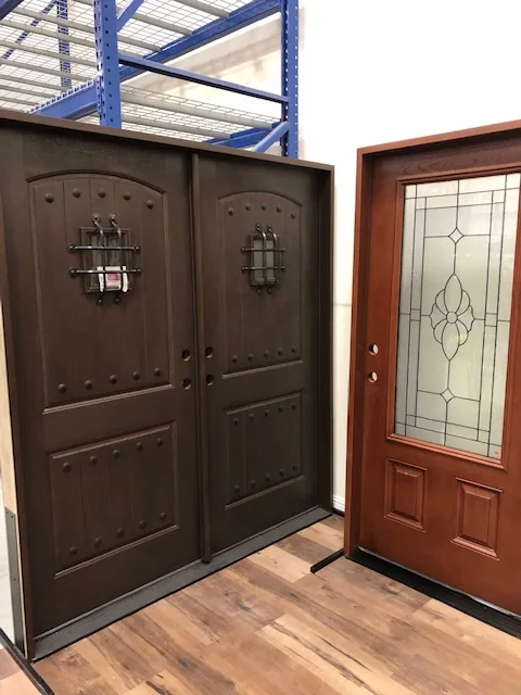 Dark rustic double entry doors beside a door with leaded glass