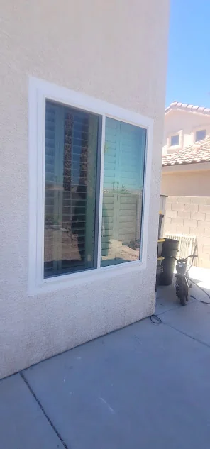 Freshly installed sliding window with shutters visible behind the glass