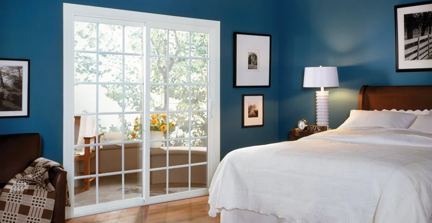 Bedroom with a white patio sliding door with grid bars